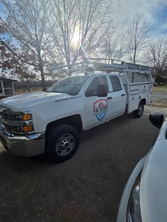 Victory's white service truck with the red and blue crest on the door and HVACR# 0004524 on the fender